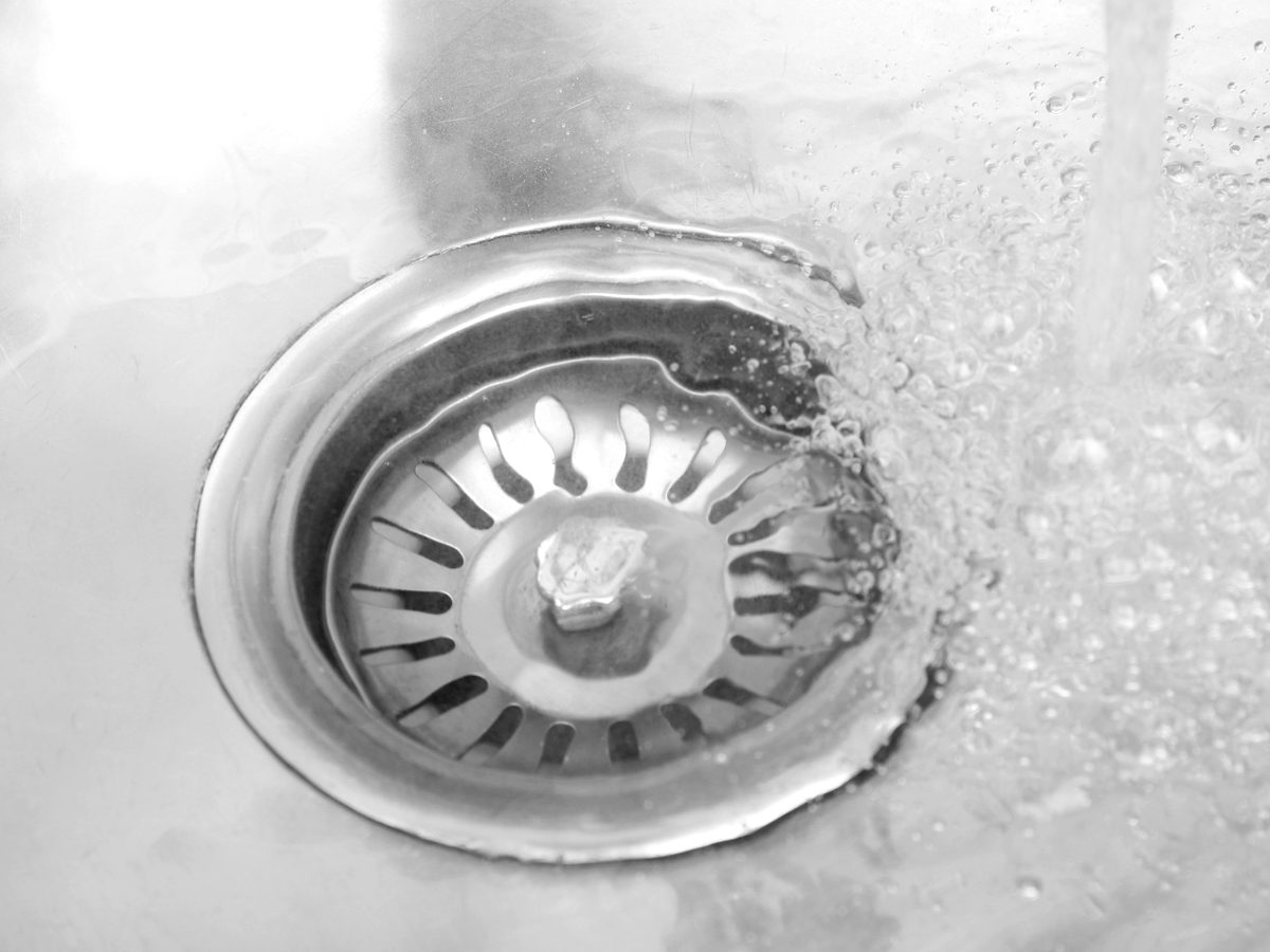 Water flowing out of a kitchen sink drain hole