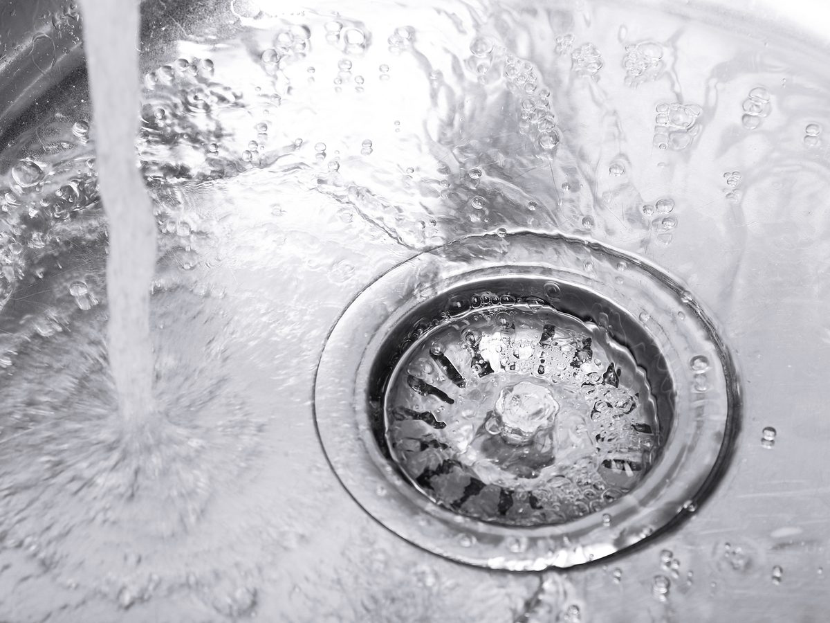 Water running down the waste hole of a kitchen sink
